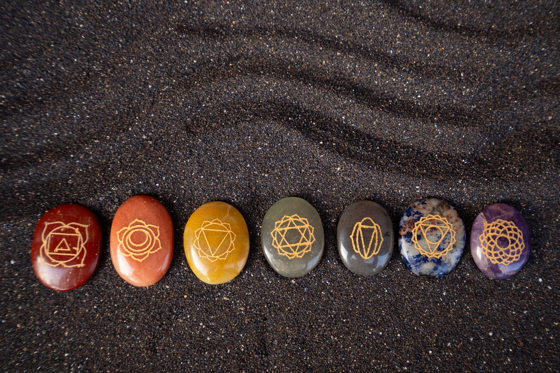 Healing crystals on black sand background